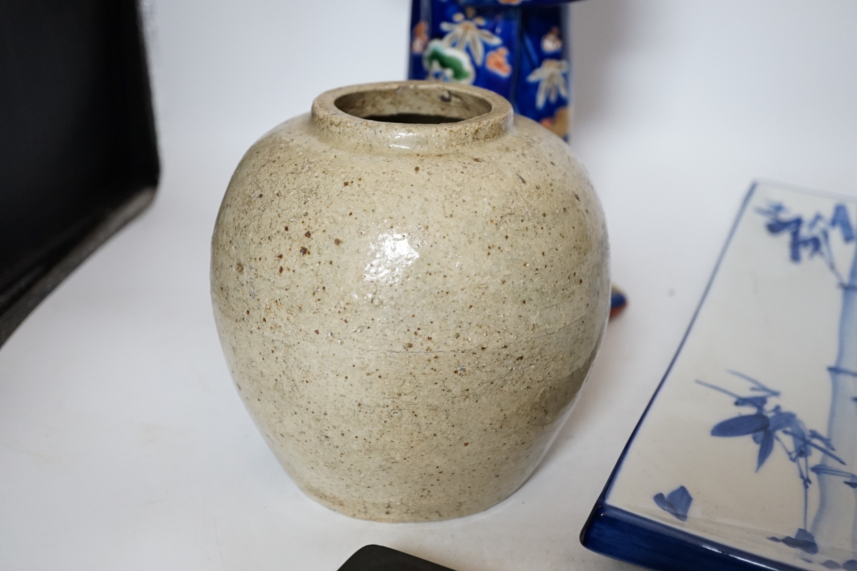A 20th century Chinese porcelain figure, a stoneware jar, a ‘dragon’ inkstone and a Japanese dish, figure 37cm